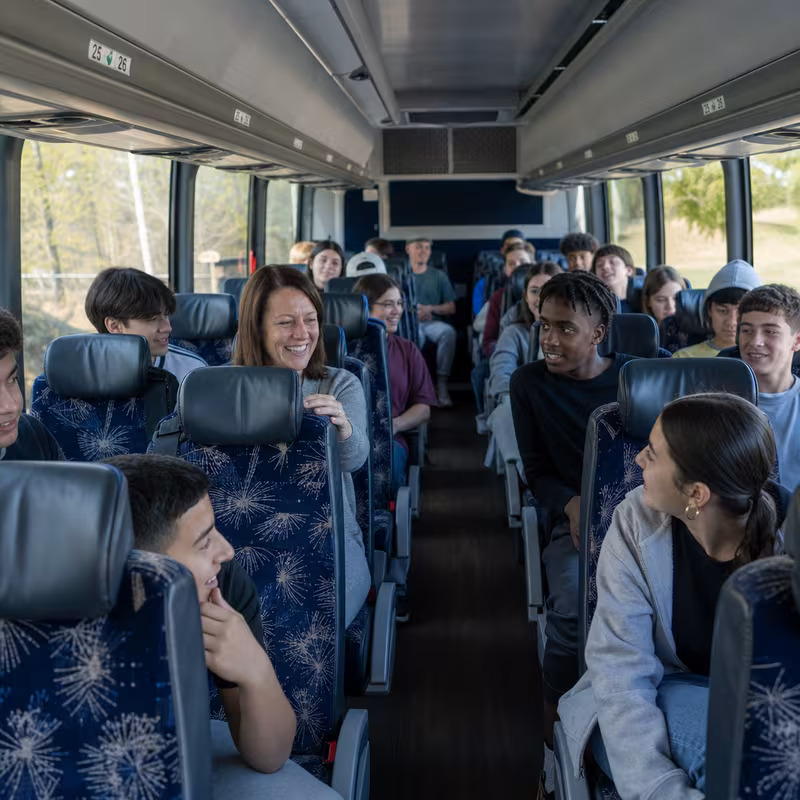 Group boarding a white charter bus for School Transportation transportation in Trenton